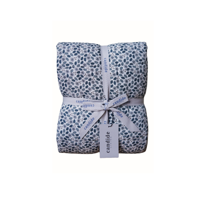 Couverture matelassée pour enfants en mousseline de coton Candide Living de motif Flora en vert sauge présentée avec ruban.