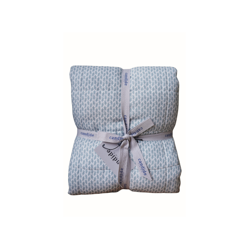 Couverture matelassée pour enfant en mousseline de coton Candide Living de motif Ondine en vert sauge présentée avec ruban. 
