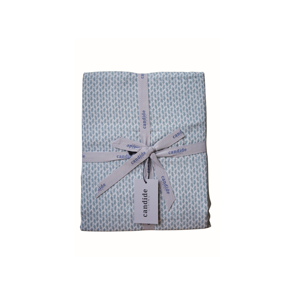 Ensemble de draps pour enfant en mousseline de coton Candide Living, motif Ondine en vert sauge, présenté avec un ruban.