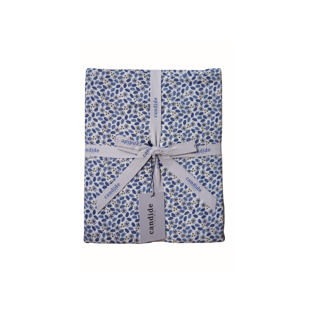 Ensemble de draps pour enfant en mousseline de coton Candide Living, motif Flora en bleu chambray, présenté avec ruban