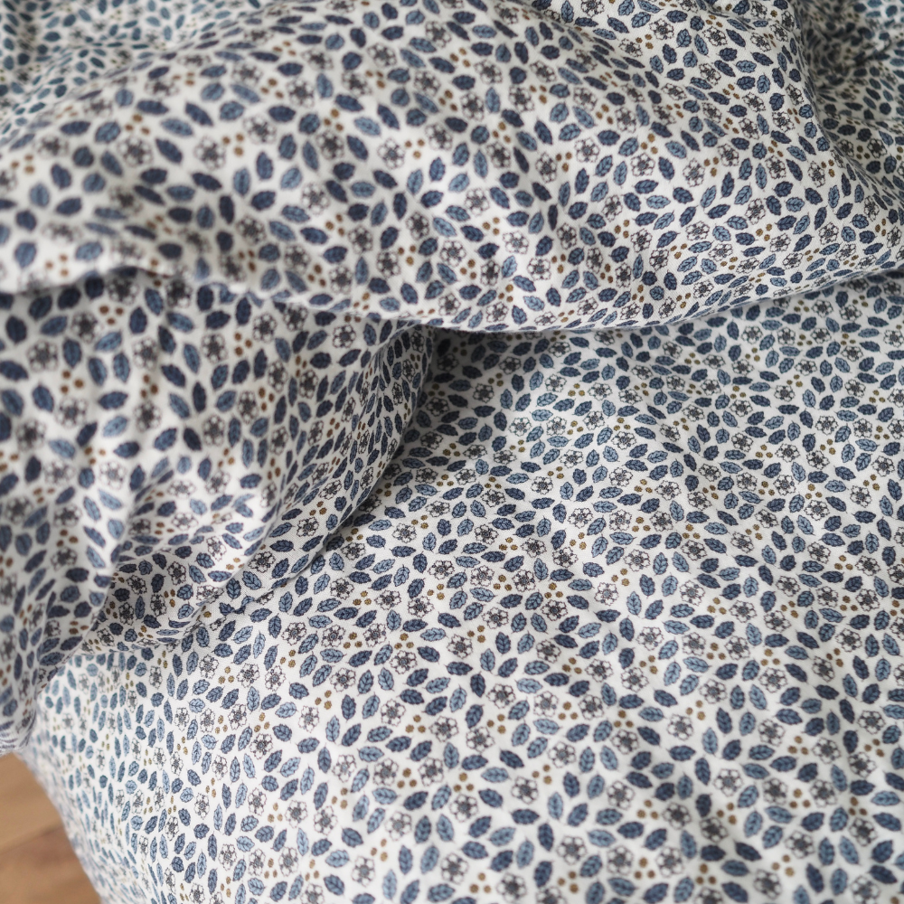 Gros plan sur l'ensemble housse de couette pour enfants en mousseline de coton Candide Living motif Flora bleu chambray.