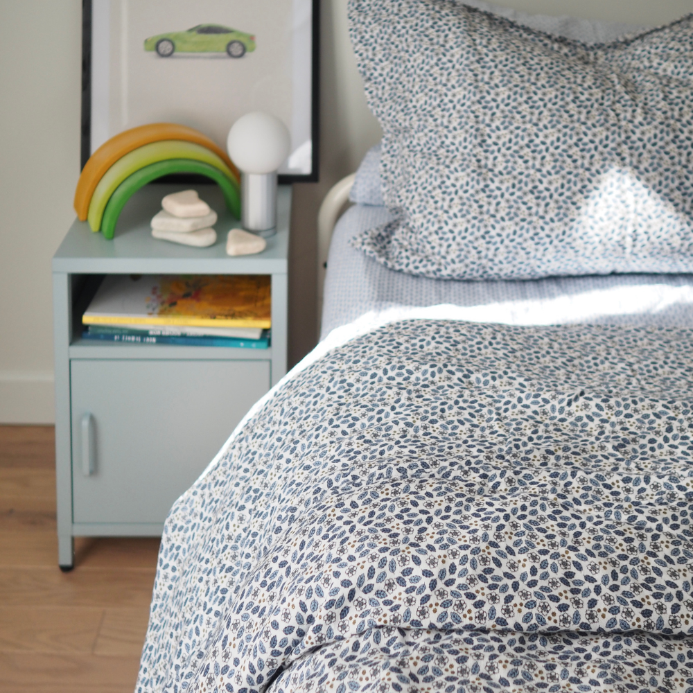 Ensemble housse de couette pour enfants en mousseline de coton Candide Living de motif Flora bleu chambray dans un décor de chambre d'enfant. 
