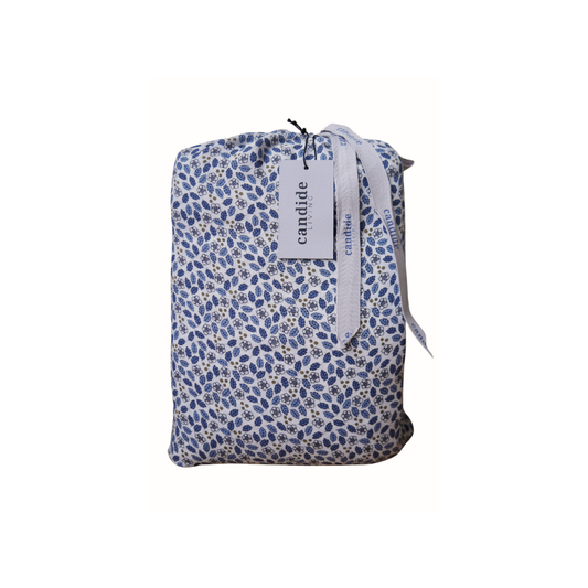 Ensemble housse de couette pour enfants en mousseline de coton Candide Living motif Flora bleu chambray présenté dans un pochon assorti. 