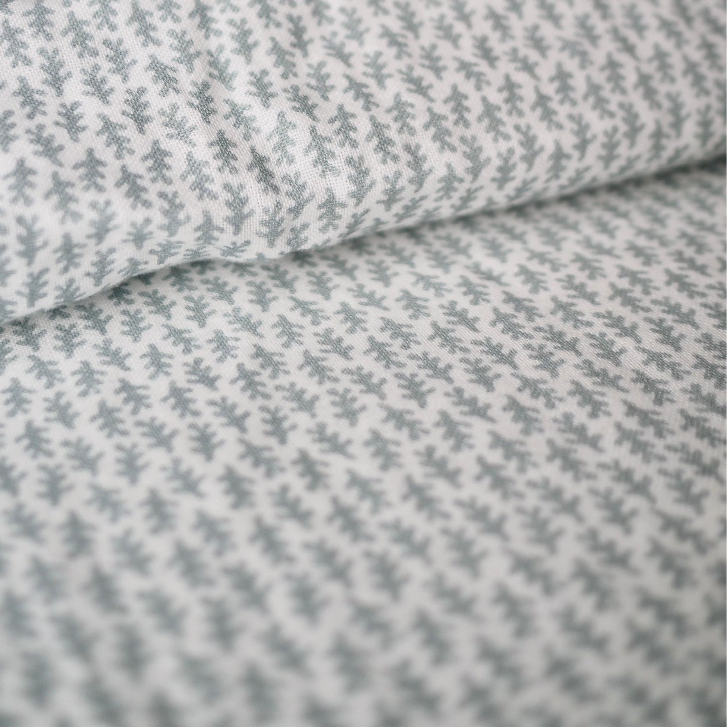 Gros plan sur l'ensemble housse de couette en mousseline de coton Candide Living de motif Ondine en vert sauge