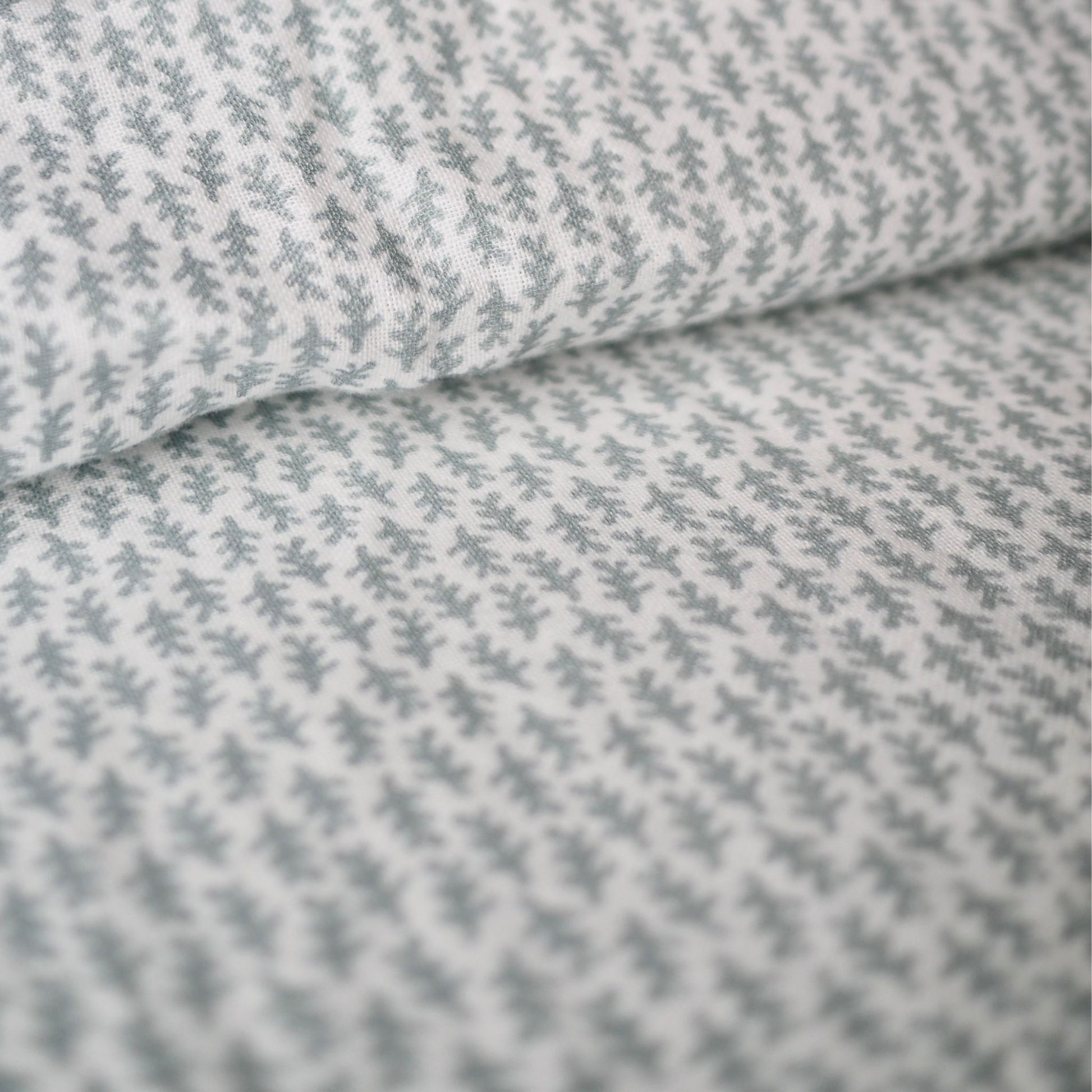 Gros plan sur l'ensemble housse de couette en mousseline de coton Candide Living de motif Ondine en vert sauge