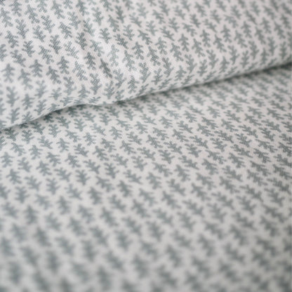 Gros plan sur l'ensemble housse de couette en mousseline de coton Candide Living de motif Ondine en vert sauge